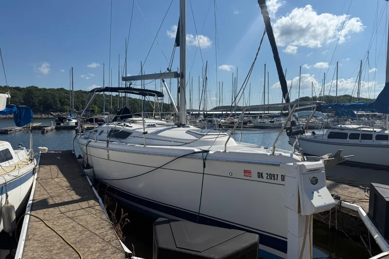 Slide: The Image of 2007 Hunter 31 sailboat docked at a marina under a clear blue sky. - 18