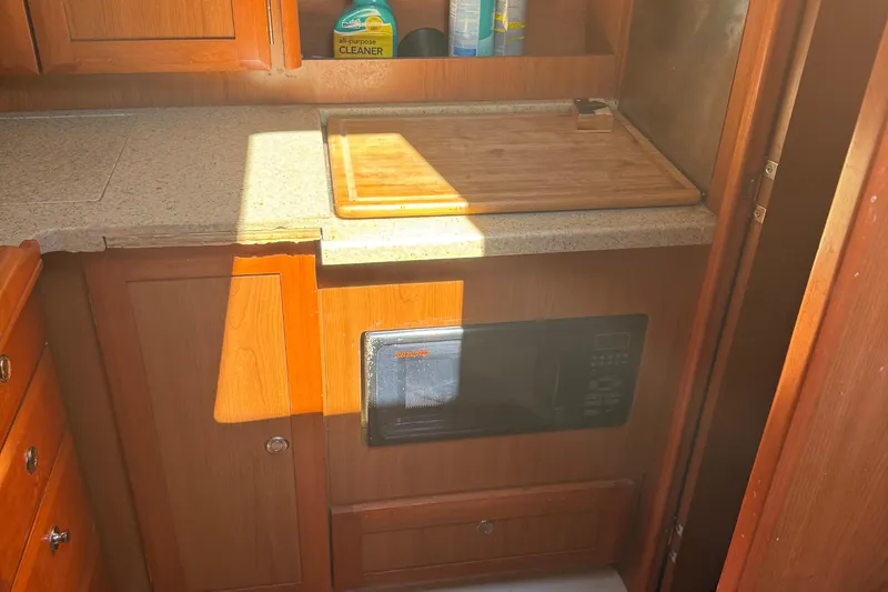 Slide: The Image of 2007 Hunter 31 yacht kitchen with wooden cabinetry, countertop, and microwave. - 6
