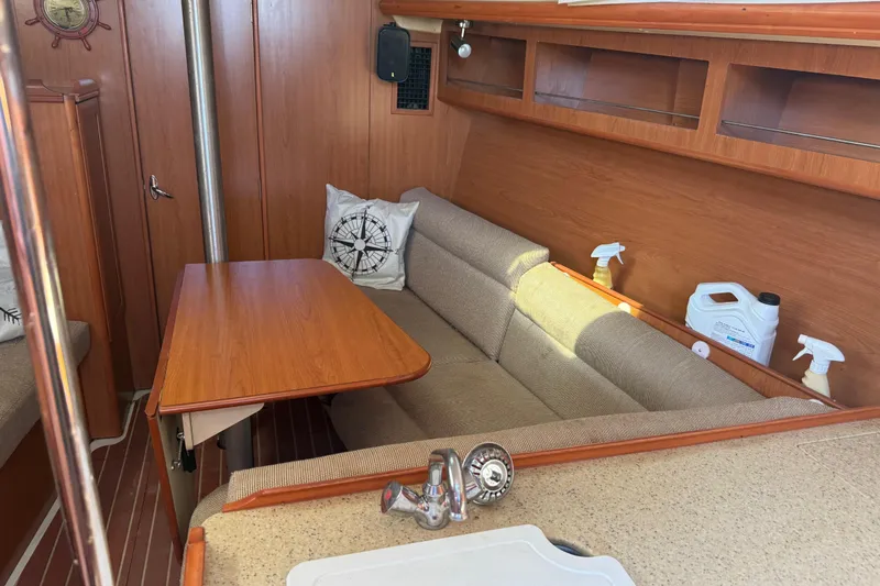 Slide: The Image of Cozy interior of 2007 Hunter 31 sailboat with wooden table and cushioned seating. - 9