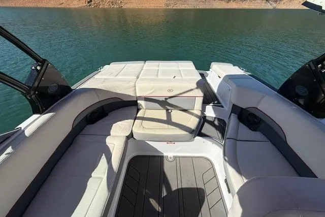 Slide: The Image of 2017 Cobalt 220S boat interior with cushioned seating on a calm lake. - 10