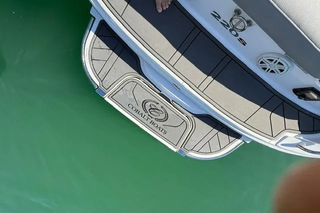 Slide: The Image of 2017 Cobalt 220S boat stern with logo, floating on clear green water. - 12