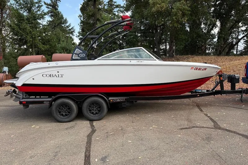 Slide: The Image of 2017 Cobalt 220S boat on trailer, white and red design, parked outdoors. - 17