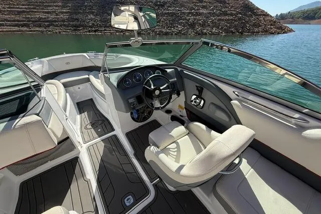Slide: The Image of 2017 Cobalt 220S boat interior with sleek design, luxurious seating, and modern dashboard on a lake. - 7