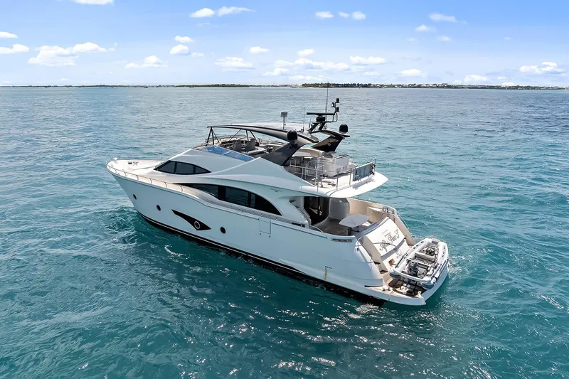 Slide: The Image of Luxury 2016 Marquis 720 Fly Bridge yacht cruising on clear blue ocean waters. - 18