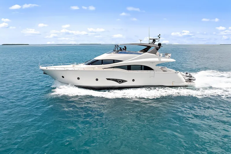 Slide: The Image of 2016 Marquis 720 Fly Bridge yacht cruising on open sea under clear blue sky. - 2