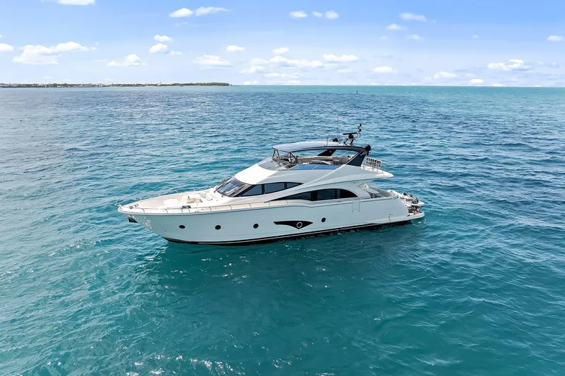 Slide: The Image of Luxurious 2016 Marquis 720 Fly Bridge yacht cruising on clear blue ocean waters. - 20