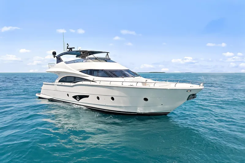 Slide: The Image of 2016 Marquis 720 Fly Bridge yacht cruising on open sea under clear blue sky. - 22