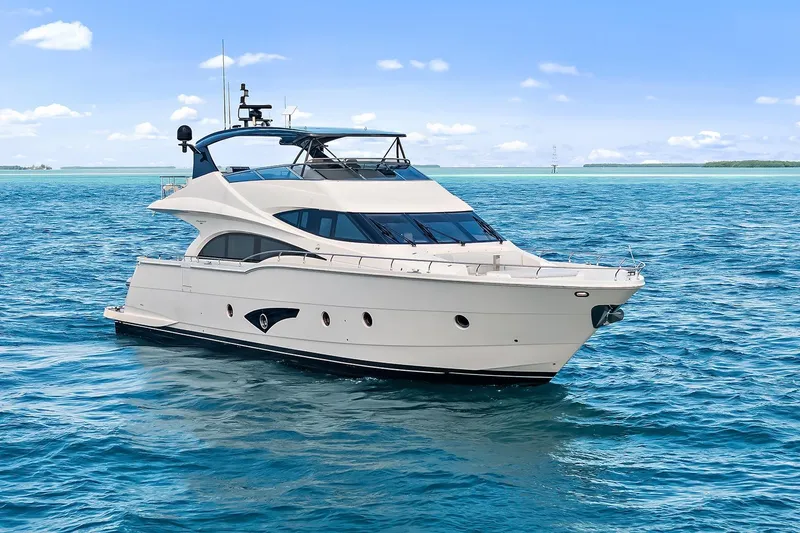 Slide: The Image of Luxury 2016 Marquis 720 Fly Bridge yacht cruising on clear blue waters. - 27