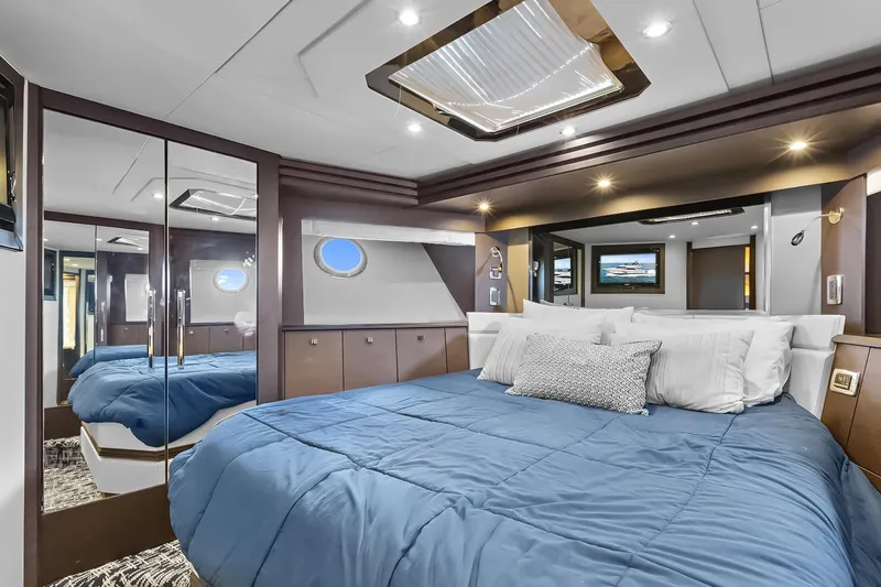 Slide: The Image of Luxurious 2016 Marquis 720 Fly Bridge yacht bedroom with blue bedding and modern decor. - 41
