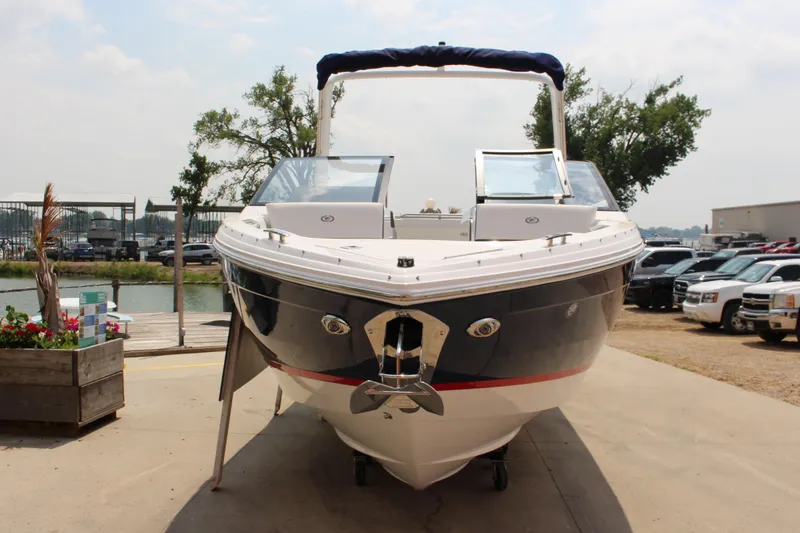 Slide: The Image of 2025 Cobalt R4 boat docked, front view, with clear skies and parked cars. - 3