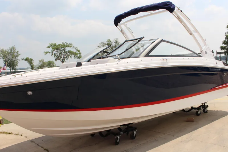 Slide: The Image of 2025 Cobalt R4 boat with sleek design, navy and white color scheme, docked outdoors. - 5