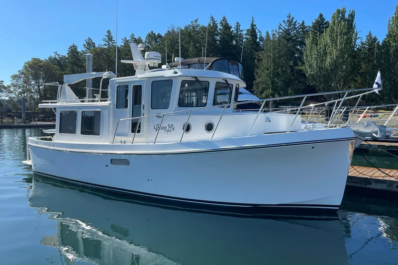 Slide: The Image of 2022 American Tug 362 boat docked in a serene marina setting. - 1