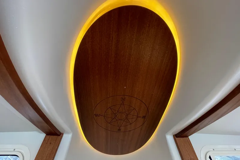 Slide: The Image of Illuminated wooden ceiling with compass design on 2022 American Tug 362 boat. - 27