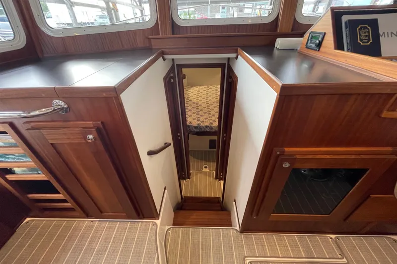Slide: The Image of Interior of 2022 American Tug 362, featuring wood cabinetry and a cozy cabin entrance. - 29