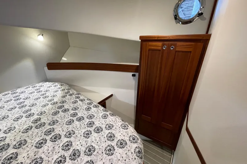 Slide: The Image of Cozy cabin interior of 2022 American Tug 362 with wooden cabinetry and patterned bedding. - 32