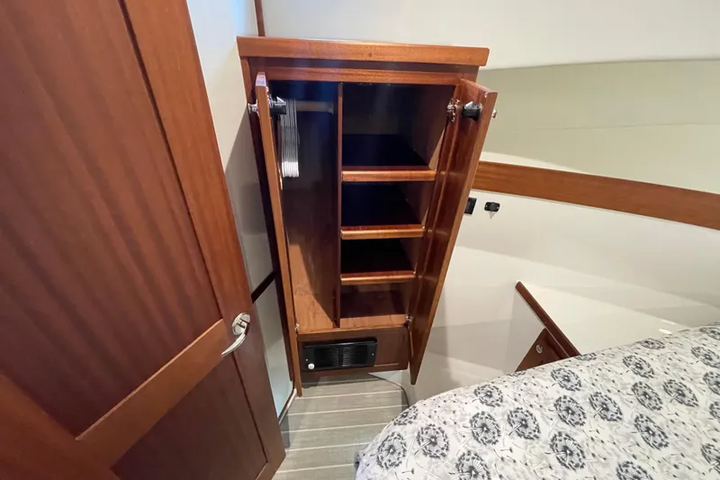 Slide: The Image of American Tug 362 (2022) interior with wooden cabinet and shelves in bedroom. - 35