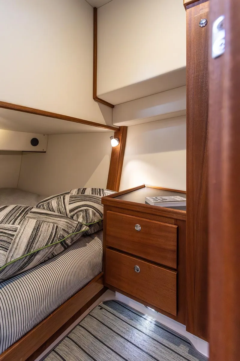 Slide: The Image of Cozy cabin interior of 2026 American Tug 362 with wooden furnishings and striped bedding. - 38