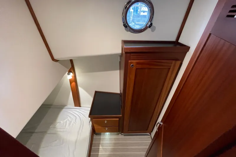 Slide: The Image of 2022 American Tug 362 cabin interior with wooden cabinetry and porthole window. - 41