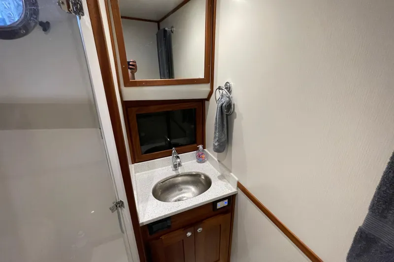 Slide: The Image of Bathroom interior of 2022 American Tug 362 with sink, mirror, and towel. - 45