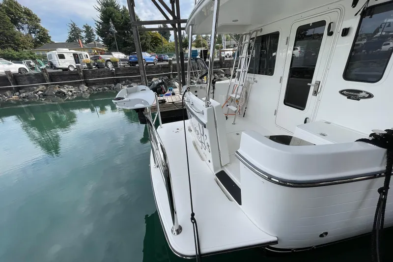 Slide: The Image of 2022 American Tug 362 docked, showcasing rear deck and water reflection. - 56