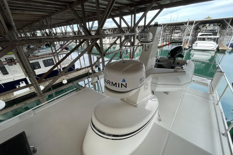Slide: The Image of 2022 American Tug 362 docked, featuring Garmin radar equipment under a covered marina. - 61