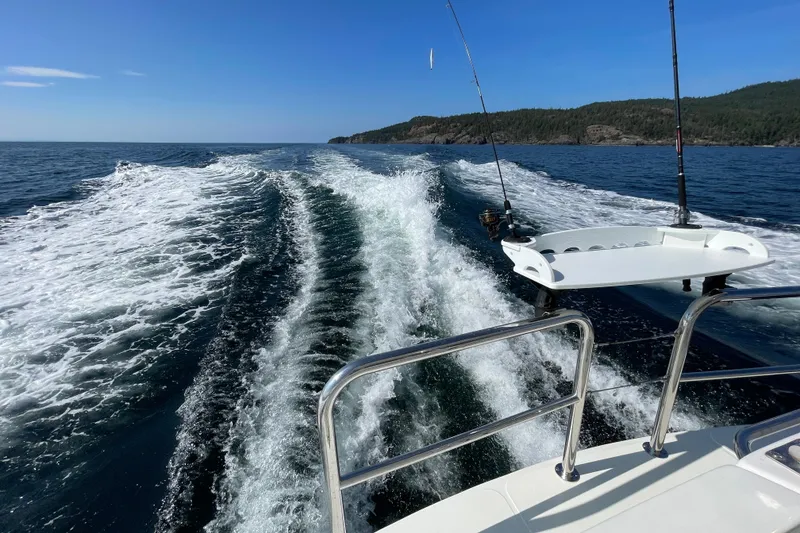 Slide: The Image of American Tug 362 (2022) cruising on open water, leaving a foamy wake behind. - 63