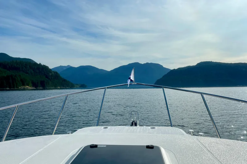 Slide: The Image of American Tug 362 (2022) cruising on a serene lake with mountainous backdrop. - 7