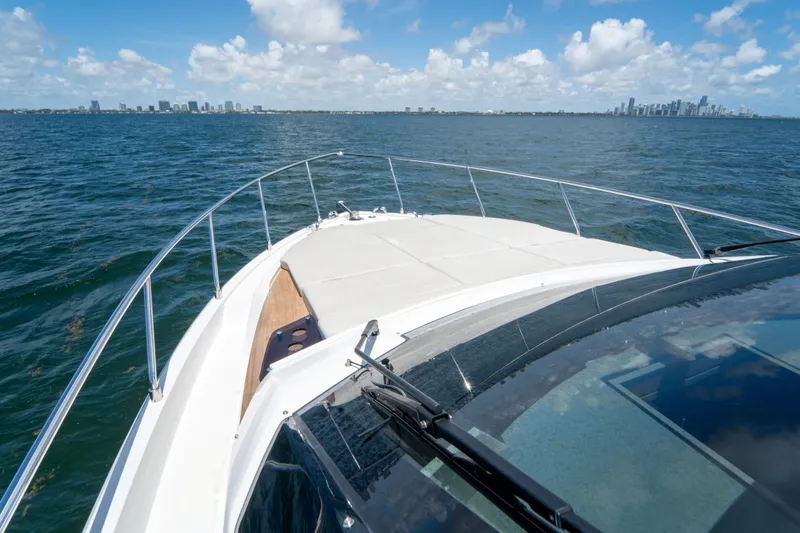 Slide: The Image of Ferretti Yachts 500 cruising on open water, city skyline in background, 2022 model. - 43