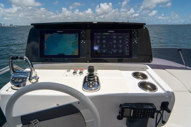 Slide: The Image of 2022 Ferretti Yachts 500 helm with dual Simrad displays, joystick, and controls. - 51