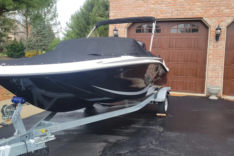 The Image of 2025 Bayliner Element M17 boat on trailer, parked in driveway with garage backdrop. - 0