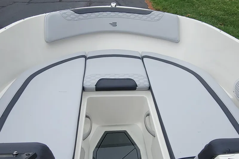 Slide: The Image of 2025 Bayliner Element M17 boat interior with gray cushioned seating and storage compartment. - 11
