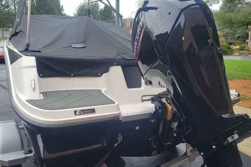 Slide: The Image of 2025 Bayliner Element M17 boat with Mercury outboard motor, covered and parked outdoors. - 4