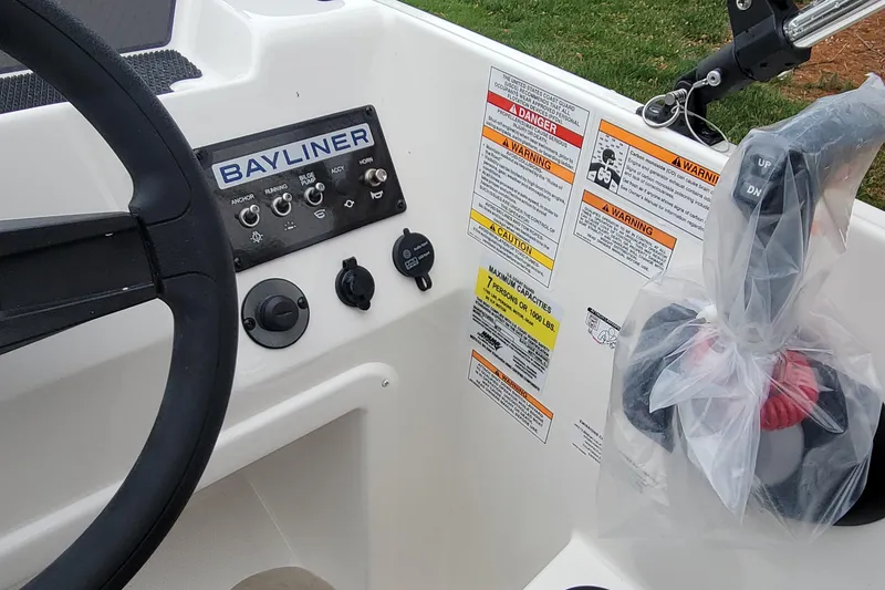 Slide: The Image of 2025 Bayliner Element M17 boat dashboard with steering wheel and control panel. - 9