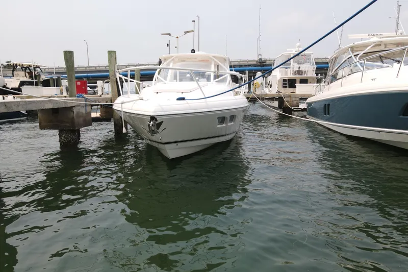 Slide: The Image of 2010 Intrepid 390 Sport Yacht docked at marina, surrounded by water and other boats. - 16