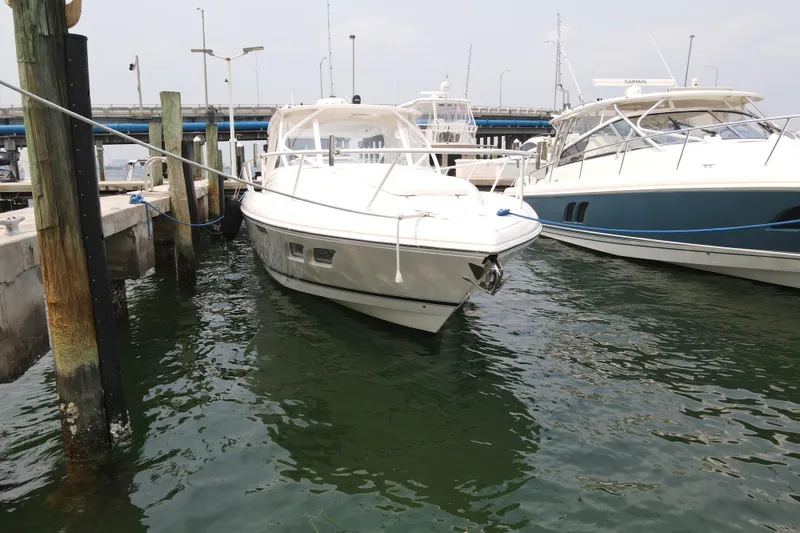 Slide: The Image of 2010 Intrepid 390 Sport Yacht docked at marina, surrounded by water and other boats. - 17