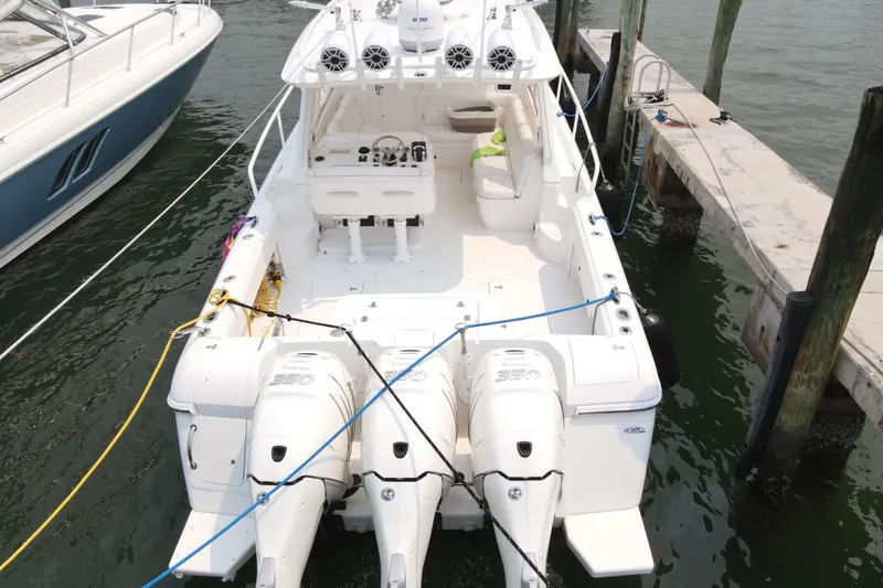 Slide: The Image of 2010 Intrepid 390 Sport Yacht docked, featuring triple outboard engines and spacious deck. - 25