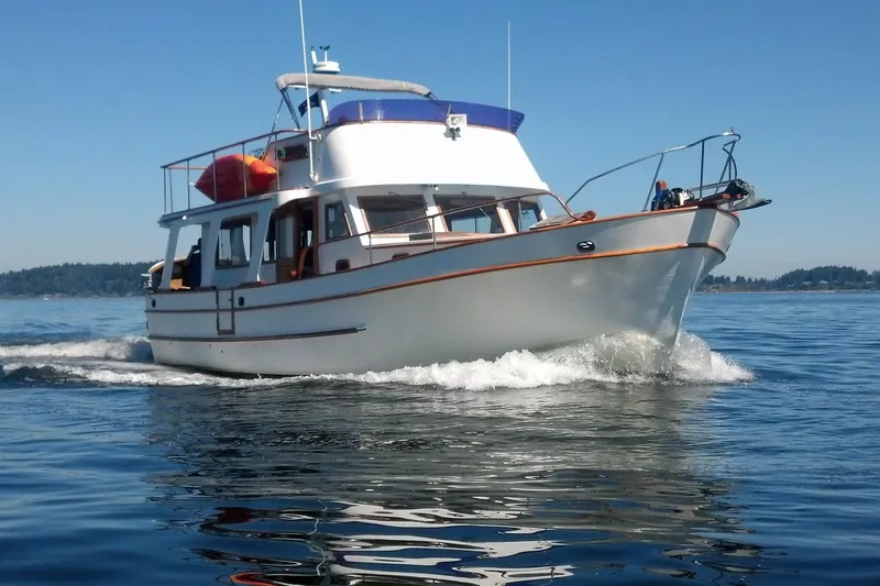 The Image of 1978 Puget 38 Europa Trawler cruising on calm blue waters under clear skies. - 0