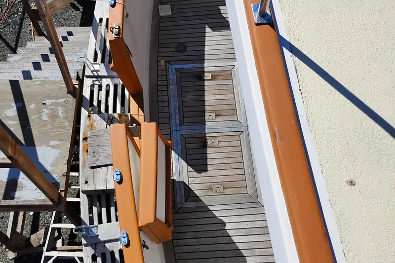 Slide: The Image of 1978 Puget 38 Europa Trawler deck with wooden panels and orange railings. - 10