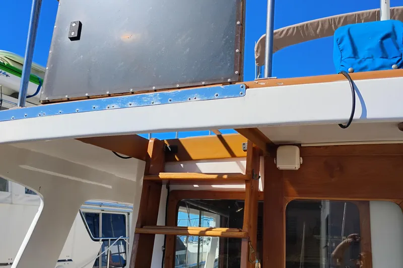 Slide: The Image of 1978 Puget 38 Europa Trawler with wooden ladder and blue sky background. - 11