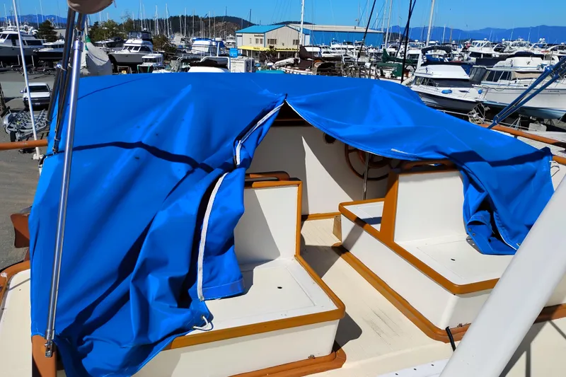 Slide: The Image of 1978 Puget 38 Europa Trawler with blue cover in marina setting. - 16