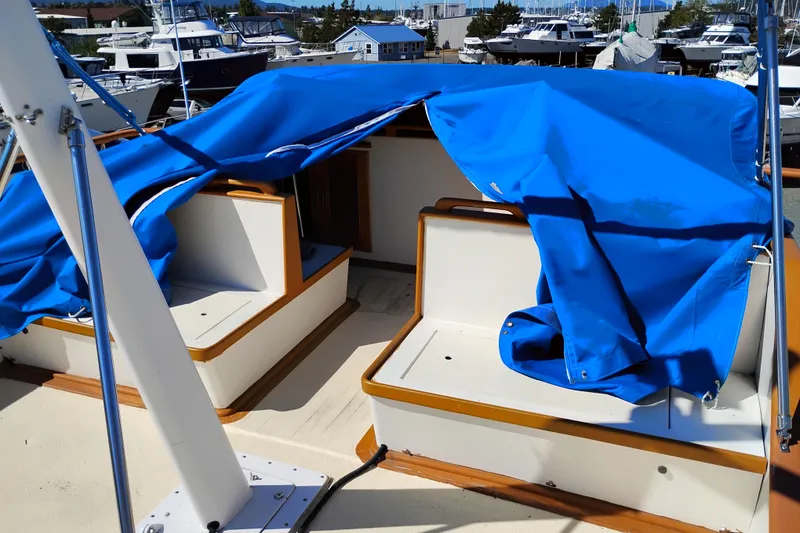 Slide: The Image of 1978 Puget 38 Europa Trawler with blue covers in a marina setting. - 17