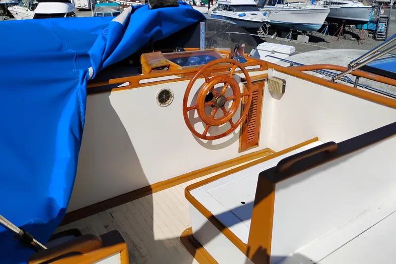 Slide: The Image of 1978 Puget 38 Europa Trawler helm with wooden wheel and blue cover. - 18