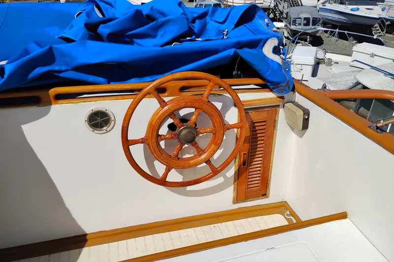 Slide: The Image of 1978 Puget 38 Europa Trawler helm with wooden wheel and blue cover. - 19