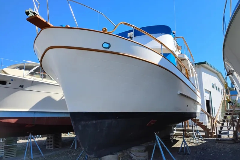 Slide: The Image of 1978 Puget 38 Europa Trawler on dry dock, showcasing classic design and sturdy build. - 2