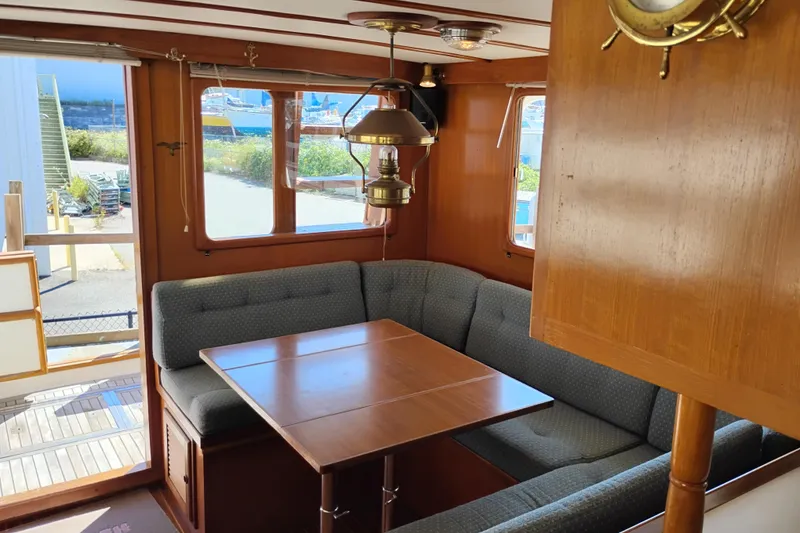 Slide: The Image of Interior of 1978 Puget 38 Europa Trawler with cozy dining area and wooden accents. - 22
