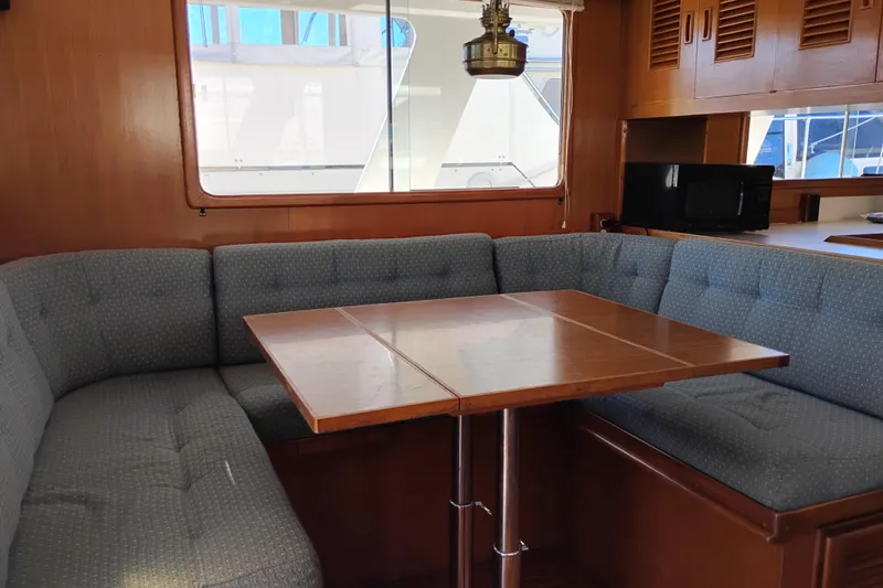 Slide: The Image of 1978 Puget 38 Europa Trawler interior with cozy dining area and wooden table. - 24