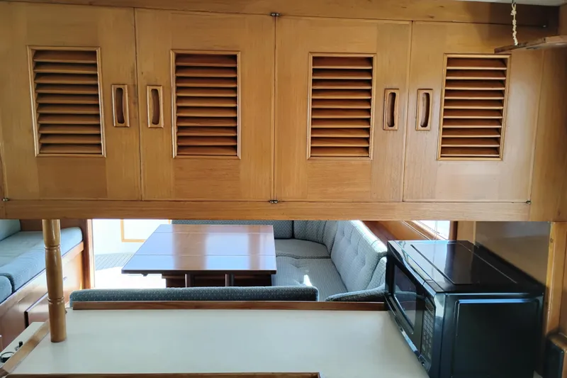 Slide: The Image of Interior of 1978 Puget 38 Europa Trawler with wooden cabinets and seating area. - 29