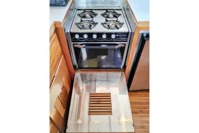 Slide: The Image of 1978 Puget 38 Europa Trawler kitchen with stove and oven, featuring wooden cabinetry. - 34