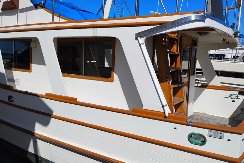 Slide: The Image of 1978 Puget 38 Europa Trawler with wooden accents and open deck, docked at marina. - 4
