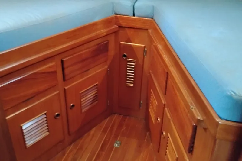 Slide: The Image of Wooden interior of 1978 Puget 38 Europa Trawler with blue cushions and storage cabinets. - 44